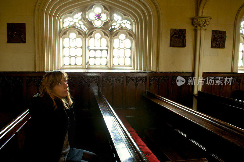 女人在教堂祈祷，等待着