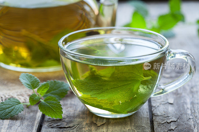 新鲜的天然绿色梅利莎花草茶在玻璃杯中。有机