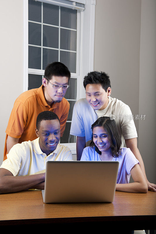 不同的大学生在笔记本电脑上。