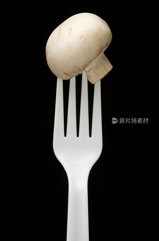 塑料叉子上的整个白色蘑菇
