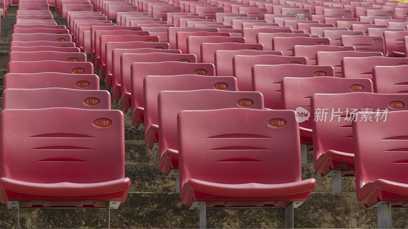 球场上空荡荡的红色塑料体育场座位。