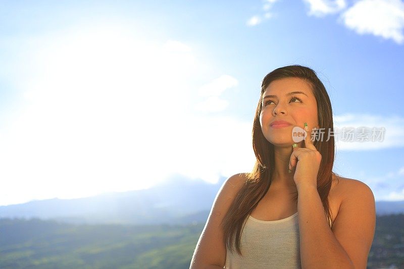 年轻的女士思考太阳背后