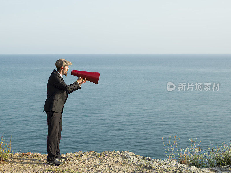 成年男子在室外通过老式扩音器大喊大叫