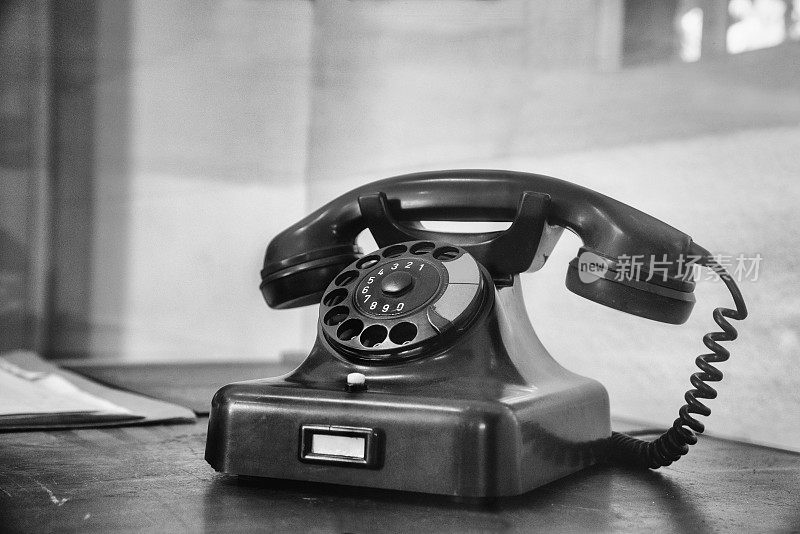 老式电话与拨号盘在旧桌子上