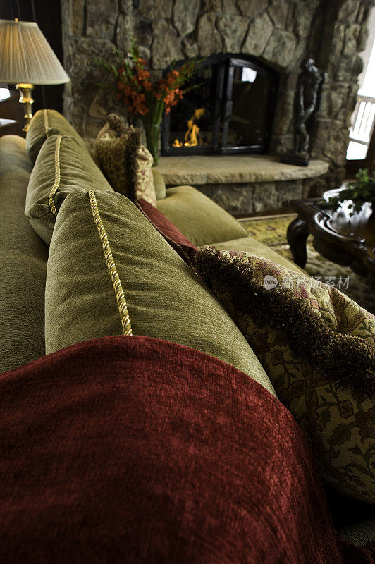 舒适舒适的沙发和枕头在壁炉前