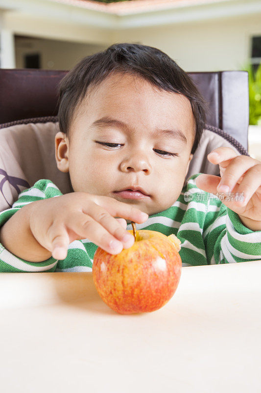 可爱的拉丁幼儿拿着苹果