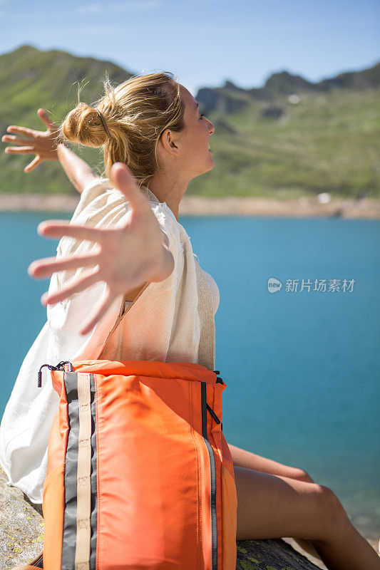 年轻美丽的女人向大自然张开双臂――夏天