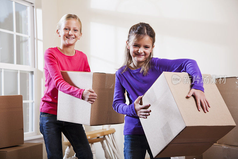 两个小女孩在帮着搬箱子