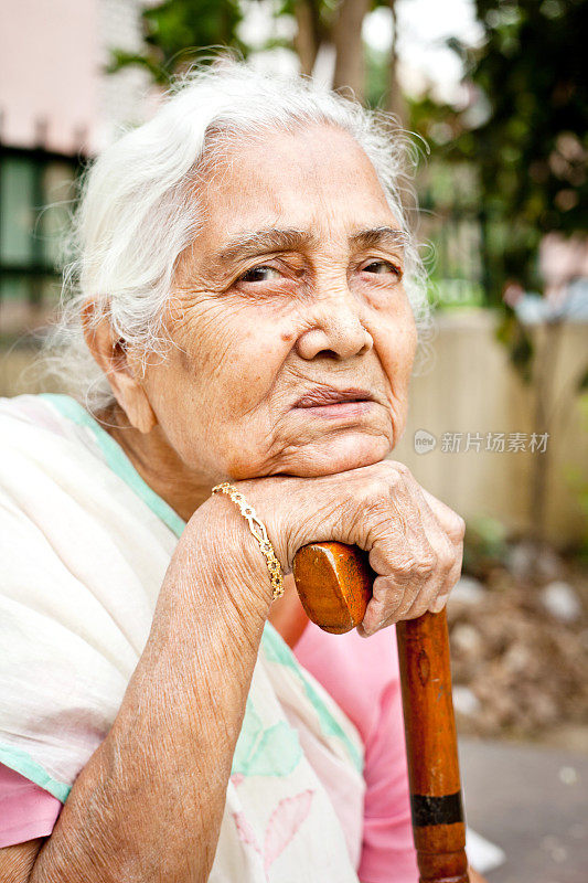 一位悲伤沉思的印度老妇人坐在户外