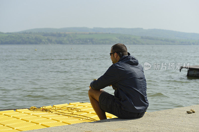 一个年轻人坐在湖边