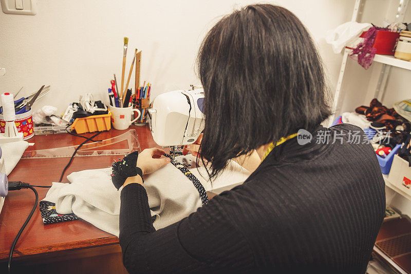 女裁缝使用缝纫机，后视图