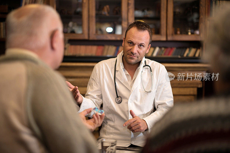 中年医生在家和他的老年病人谈话。