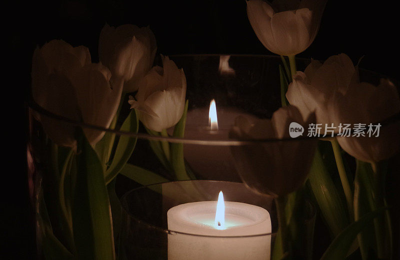 蜡烛插在插着郁金香的花瓶里