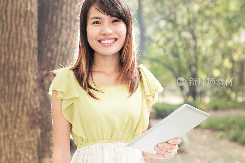 亚洲女学生在校园里用平板电脑的肖像