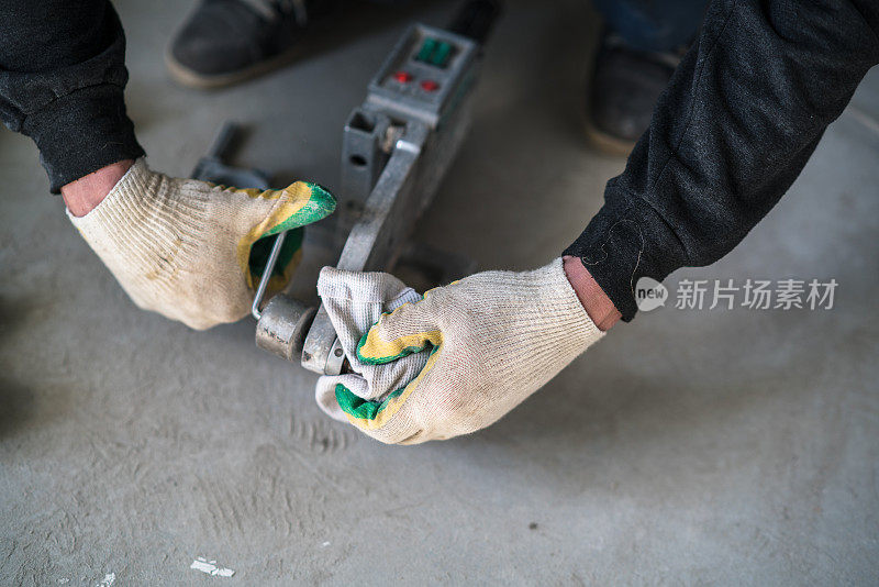 手工工人的手:管子工用专用的热工具连接塑料管
