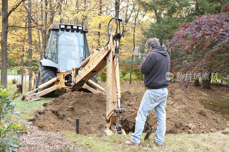 一名男子用挖掘机挖掘油罐