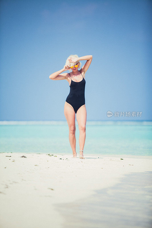 金发女人在马尔代夫的沙滩上