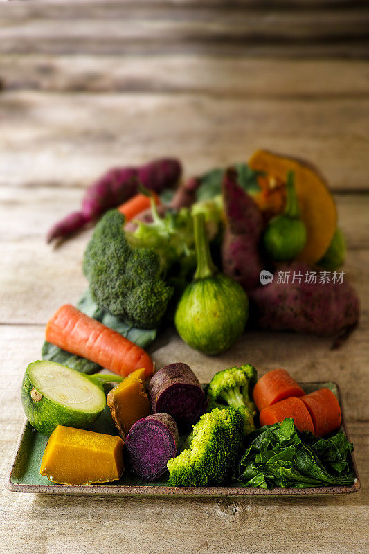 新鲜的清蒸蔬菜放在长方形的绿色瓷盘上，直接从蒸笼出来。