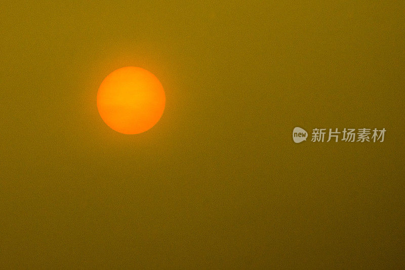 橙色的太阳映衬着暴风雨般的黄色天空