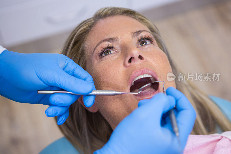 牙医用工具检查一位女病人