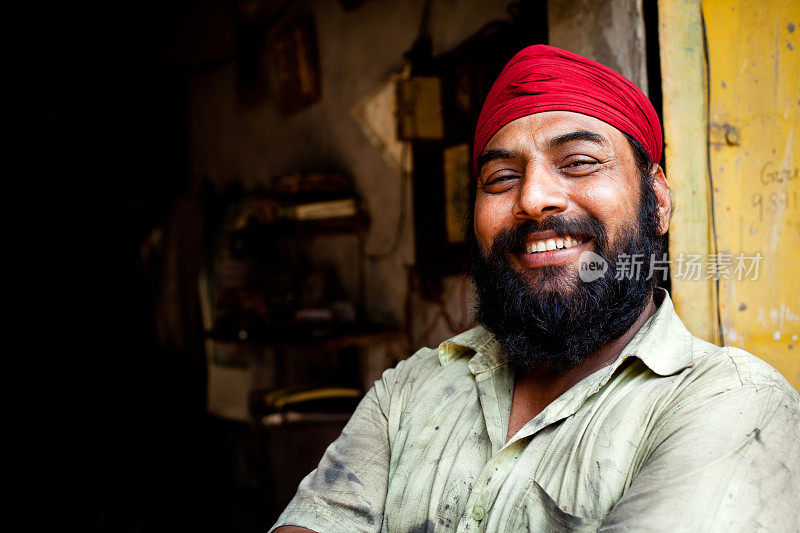 快乐的印度锡克教机械手工工人的肖像