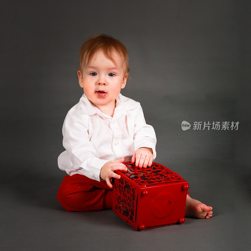 穿着白衬衫和红裤子的男婴在玩耍