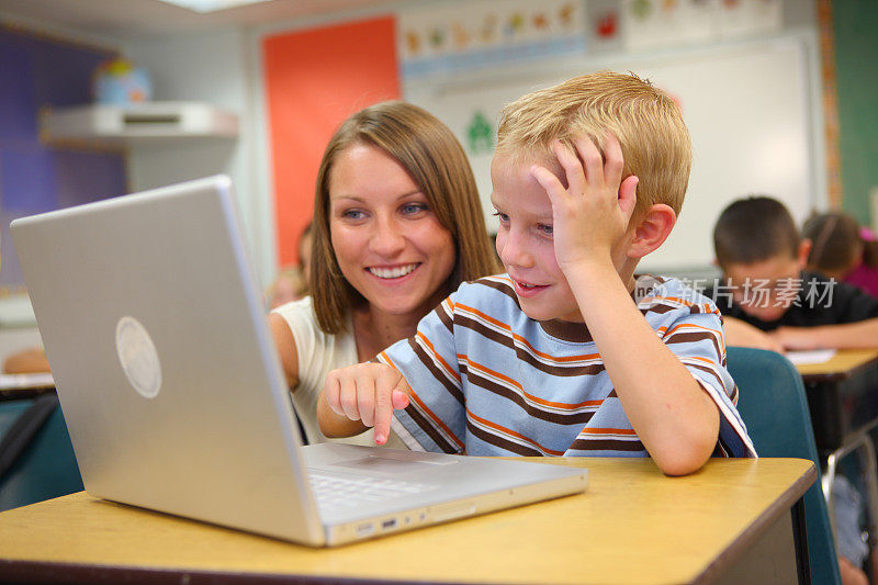 小学生和老师看电脑