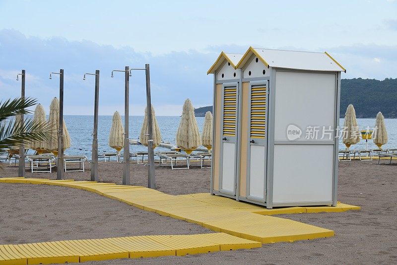 海滩设备:木板路、淋浴器、移动厕所、雨伞和躺椅