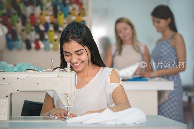快乐的时装设计师在缝纫工作室