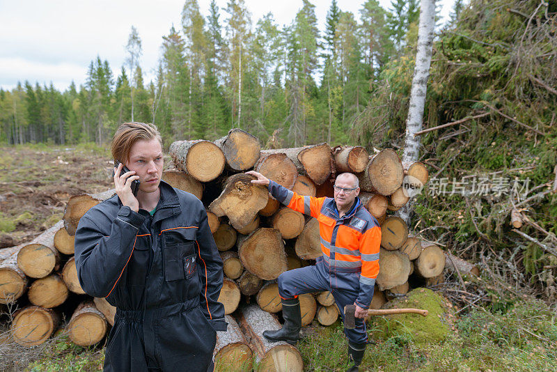 一个成熟的男人和一个年轻的男人一起在森林里工作