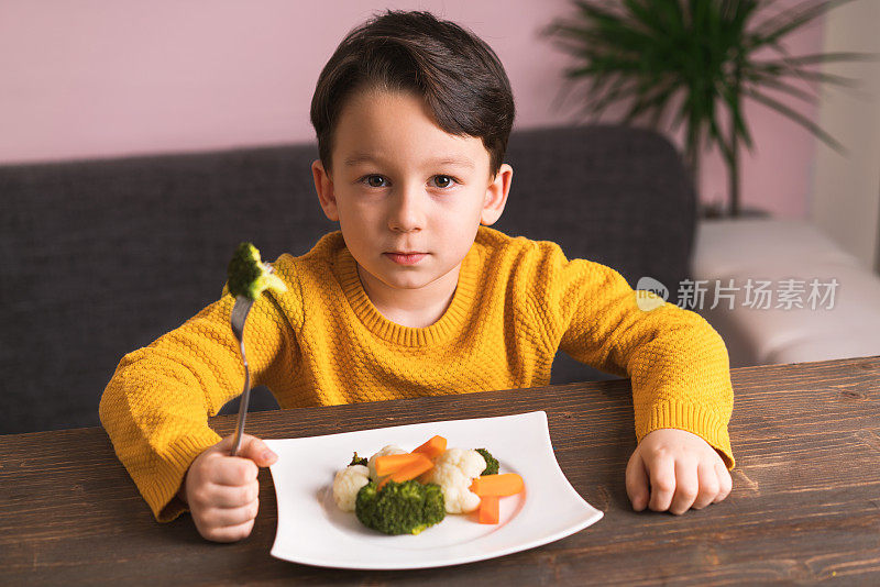 孩子对不得不吃蔬菜很不高兴。