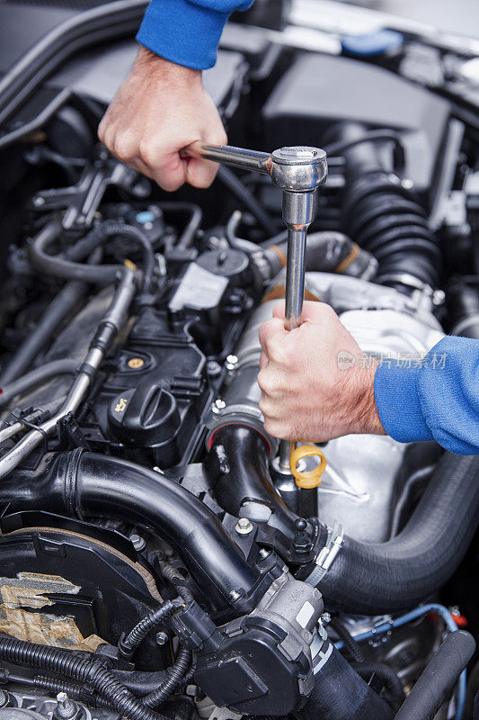 汽车修理工在修理厂修理汽车发动机。