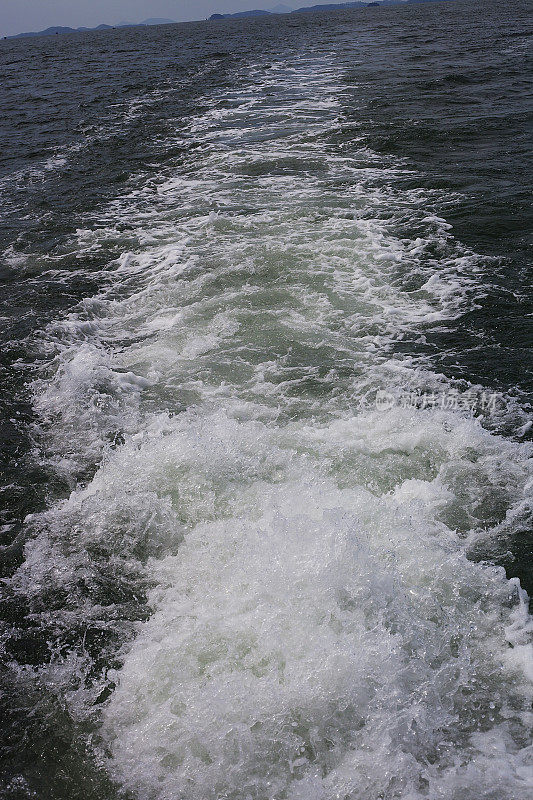 漂浮的小船在水面上激起白色的浪花