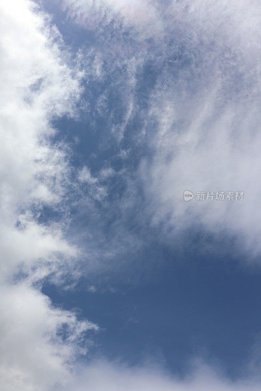 蓝色天空映衬着蓬松、缕缕白云的特写