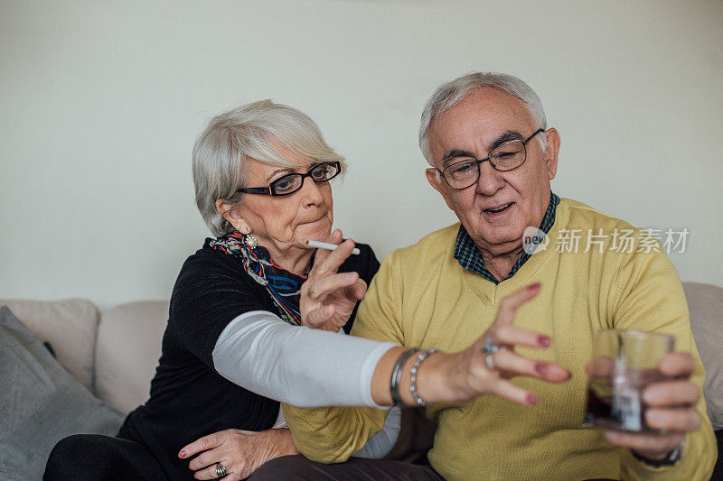 成熟的女人从抽烟的男人手里接过一杯水