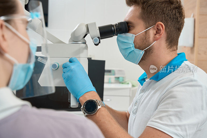 经验丰富的口腔医生为牙科工作调整光学仪器