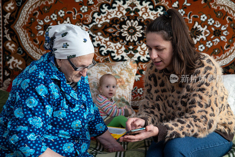 这位女士向她的祖母解释如何使用智能手机。