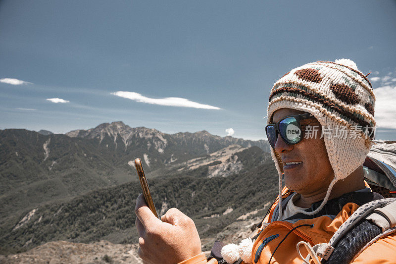 登山客在山顶使用智能手机。