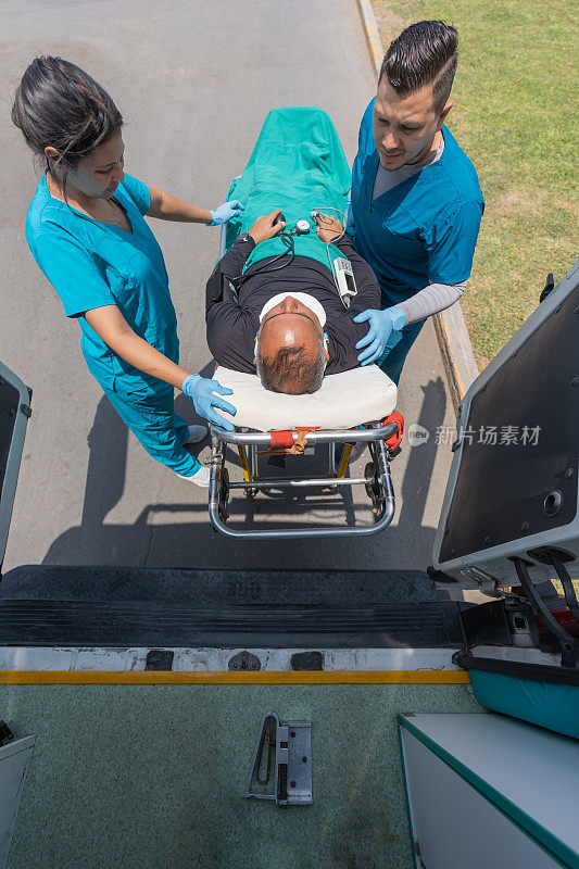 医护人员用担架抬着一名戴着颈圈的病人从救护车上下来