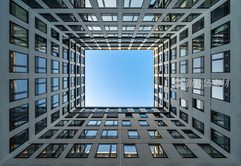 现代办公大楼的低角度视图，对着清澈的蓝天