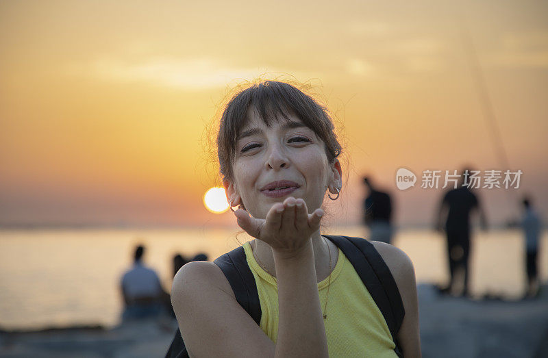 女人在日落时飞吻