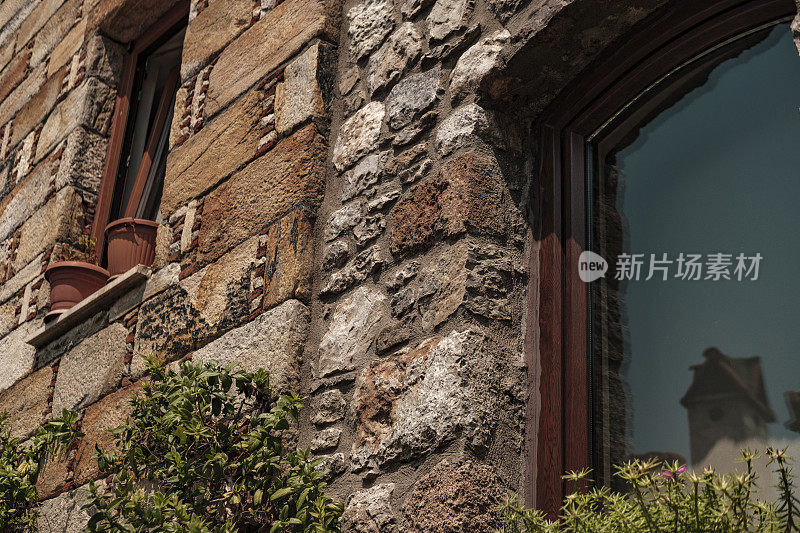 石砌拱形窗墙，花盆花，窗台上，古风建筑，现代潮流岩石纹理外饰