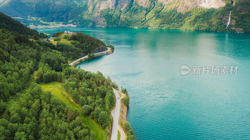 在水晶蓝峡湾与山景风景优美的夏季景观中汽车驾驶鸟瞰图