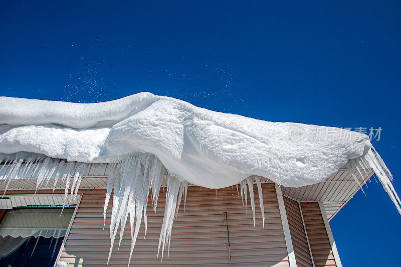 屋顶上挂着雪堆和冰柱