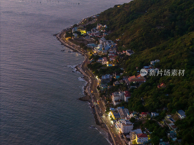 从上面俯瞰云头海岸全景，海浪、海岸线、街道、椰子树、越南Nho山后面的基督国王雕像