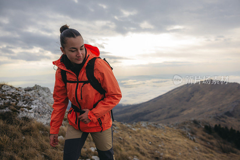 年轻的女徒步旅行者正在爬山