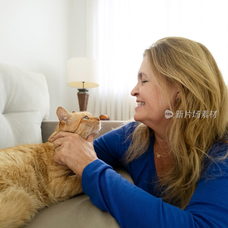 女人和他的姜黄色猫在家里。