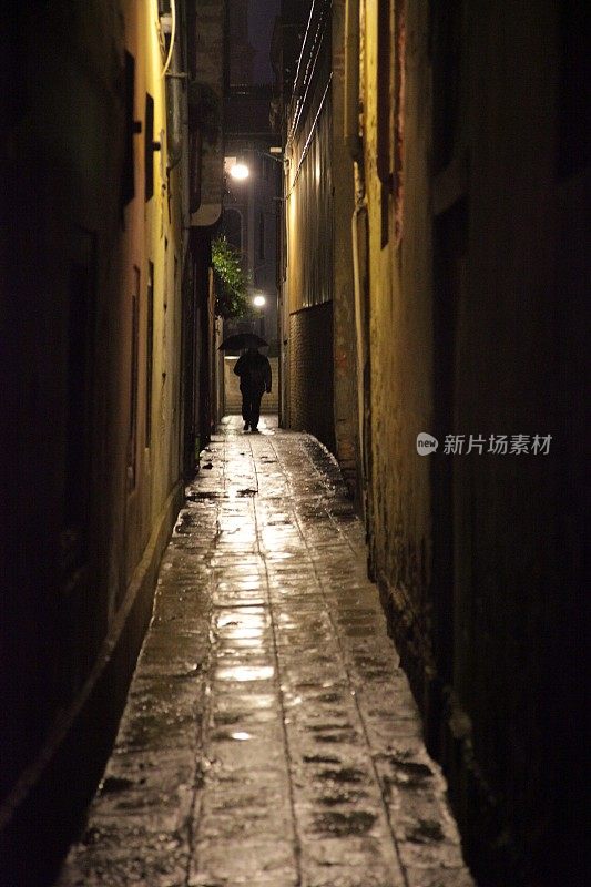 意大利威尼斯，夜雨中打着伞的身影