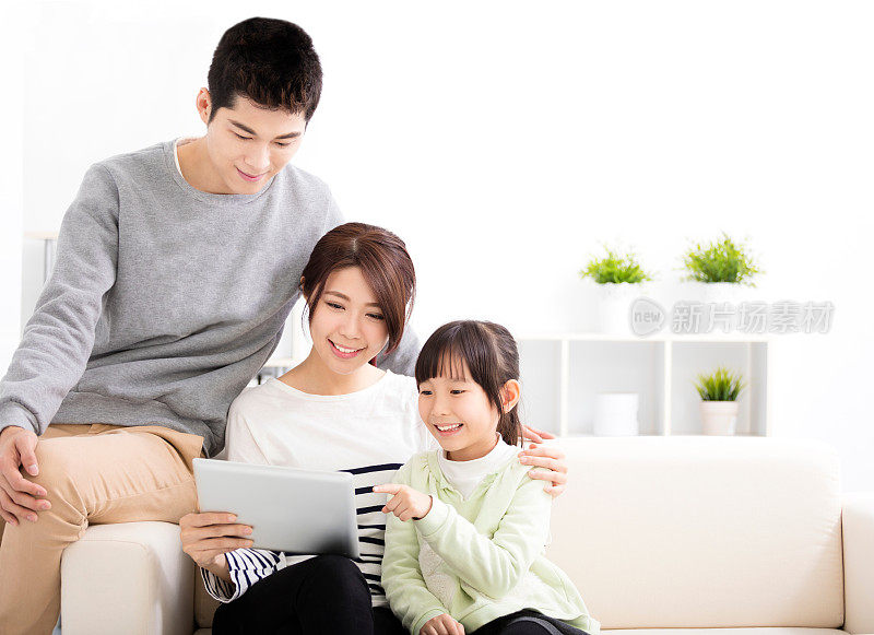 快乐有吸引力的年轻家庭看平板电脑