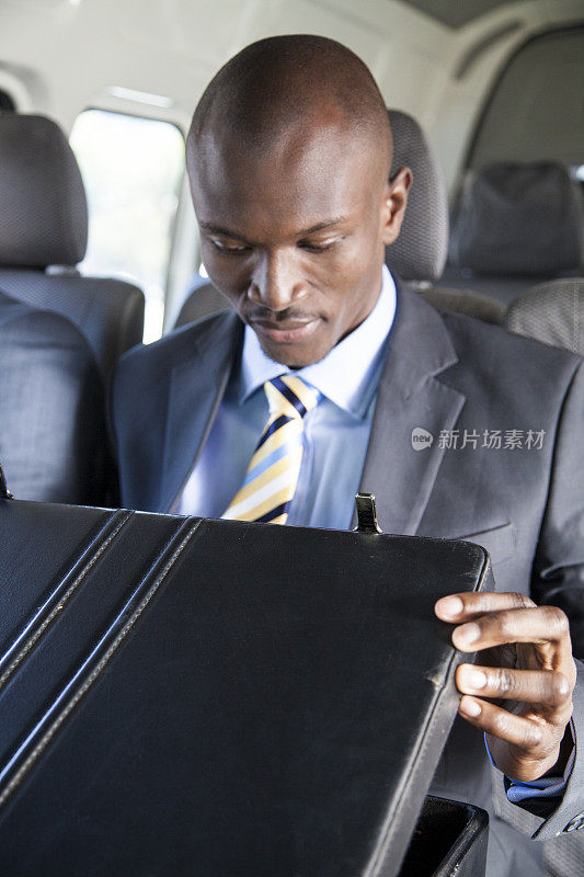 一个非洲商人在出租车里打开了他的公文包。